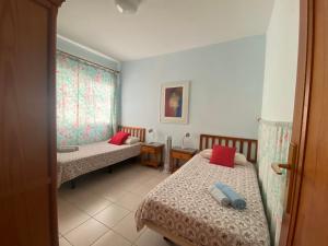 a room with two beds with red pillows at Apartamento Puerto Tazacorte in Puerto de Tazacorte