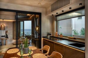 a kitchen with a table and chairs and a counter at Paragon Suites 1 in Agia Pelagia