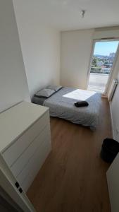 a bedroom with a bed and a large window at Élégance Parisienne in Villemomble