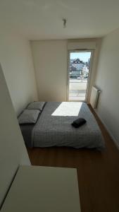 a bedroom with a bed and a large window at Élégance Parisienne in Villemomble