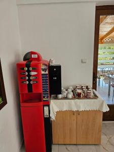 a red refrigerator next to a counter with a table at Pensiunea Esential in Ocnele Mari +33 photos