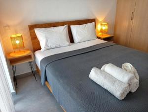 a bedroom with a large bed with two towels on it at White luxury apartment in Tríkala