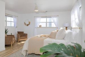 Un dormitorio blanco con una cama y una silla. en Updated & Spacious 2 BR with Free WiFi, en Oroville