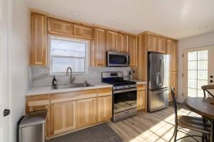 Una cocina con gabinetes de madera y electrodomésticos de acero inoxidable. en Updated & Spacious 2 BR with Free WiFi, en Oroville 24 fotos más