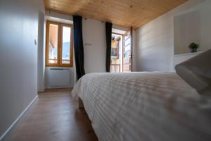 um quarto com uma cama branca e uma janela em Loft Bourg St Maurice Les Arcs La Maison des Tetes em Bourg-Saint-Maurice