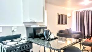 a kitchen with a stove and a living room at Palmar Hotel in Johannesburg