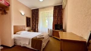 a hotel room with a bed and a television at Hotel Zhambyl in Taraz