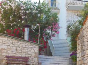 a house with flowers on the stairs and a stair case at Apartment Jurišić Korčula in Korčula