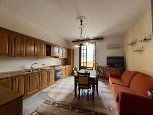 a kitchen and dining room with a table and a couch at Appartamento villa Francesca in Castelluzzo