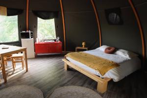 a bedroom with a bed and a table and a tableablish at Domaine du Heidenkopf in Niederbronn-les-Bains