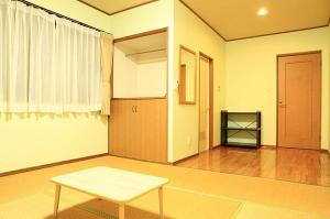 an empty living room with a table and a door at Joya in Ishigaki Island