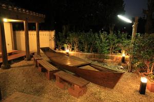 a wooden boat sitting in a garden at night at Joya in Ishigaki Island
