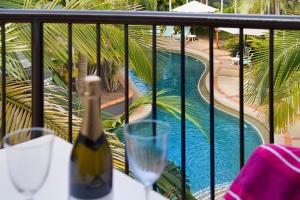 a bottle of wine sitting on a table next to a pool at Blue Waters Apartments in Gold Coast