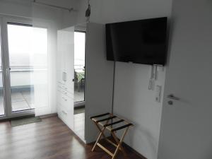 a room with a television on a wall with a stool at Apartment Schwäbisch Hall in Schwäbisch Hall