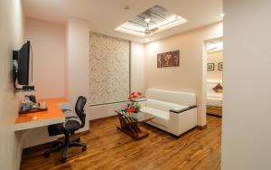 a room with a desk and a chair and a couch at Mango Hotels Prangan in Bhubaneshwar