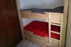 a wooden bunk bed with a red bed in a room at Chalet Saint Roch Montgenevre in Montgenèvre