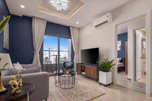 a living room with a couch and a tv at 2BDR Modern Highrise Condo, City & River views, Pool in Da Nang