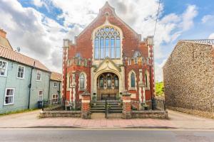 a large brick church with aificantificantificantificantificantificantificantificantificantificant at The Tracery - Norfolk Cottage Agency in Fakenham