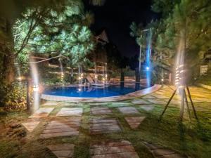 a night view of a swimming pool with lights at RcplacePH T3-413- Pinesuites Tagaytay in Tagaytay