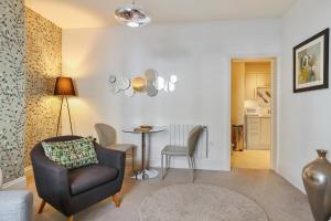 Una sala de estar con una silla y una mesa. en 3, Gainsborough House, en Cheltenham