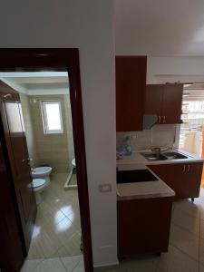 a kitchen with a sink and a toilet in a room at Ridi Apartament's in Vlorë