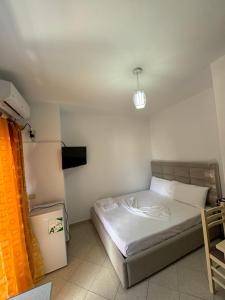 a small bedroom with a bed in a room at Ridi Apartament's in Vlorë