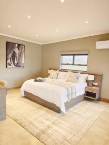 Simbini Sunset Cottage في ماليلين: غرفة نوم بسرير كبير ونافذة