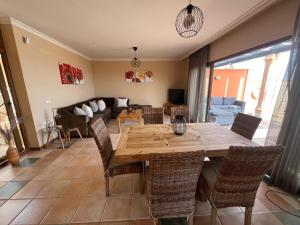 un salon avec une table et des chaises en bois dans l'établissement Villa Senorio, à Caleta de Fuste