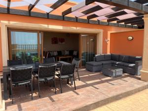 un patio avec une table, des chaises et un canapé dans l'établissement Villa Senorio, à Caleta de Fuste