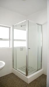 a glass shower in a bathroom with a sink at CURIOCITY Kloof Street in Cape Town
