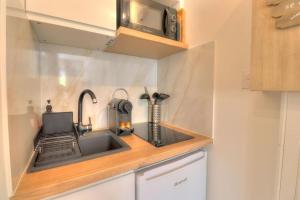 a kitchen with a sink and a microwave at Charmant Studio rénové à Antibes, plage à 10 min à pied in Antibes