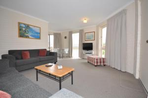 a living room with a couch and a table at The Sands Holiday Apartments in Merimbula