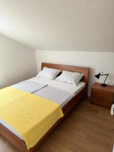 a bedroom with a bed with a yellow blanket on it at House on the hill in Mostar