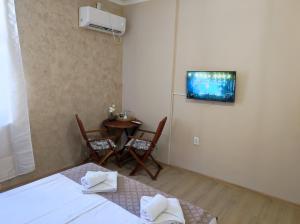 a room with two beds and a table and a tv at Guest Rooms Filipopol in Plovdiv