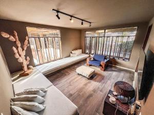 un salon avec un canapé et deux fenêtres dans l'établissement Casa com Ofurô, Piscina Aquecida e Cozinheira, à Barra do Camaragibe