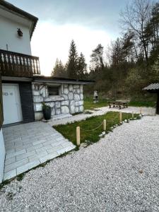a stone house with a patio and a picnic table at Riverhouse apartment in Radovljica