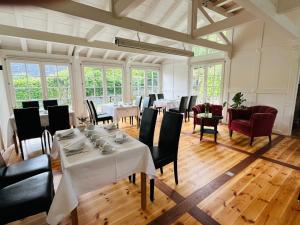 a dining room with white tables and black chairs at Hotel Hahn Gondelsheim in Gondelsheim