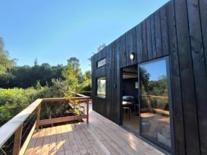 a wooden house with a large glass door on a deck at Moose home Tiny House Basalt in Cros