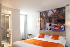 パリにあるホテル マイエのベッドルーム1室(大型ベッド1台、オレンジ色の枕付)