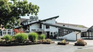 een wit gebouw met een bord waarop staat 'park hotel' bij Parkhotel Nümbrecht in Nümbrecht