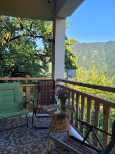 un portico con una sedia e un tavolo con fiori di GUEST HOUSE RIMAS HOME a Khulo