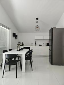 a kitchen with a table and chairs and a refrigerator at Nada Apartment, Uvala Koramaslinova, Brač in Milna