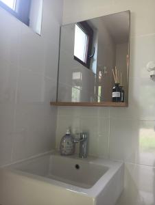 a white bathroom with a sink and a mirror at Deleni Retreat - Glamping in Buzău