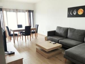 una sala de estar con un sofá y una mesa en DakarByDays-DBD008 appartement Astrid 1 chambre, en Dakar