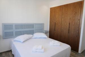 una camera da letto con un letto bianco con due asciugamani sopra di Le vert citron a Sfax