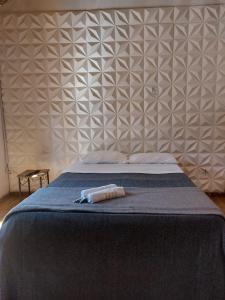 a bedroom with a blue bed with a wall at Casa Pouso Tiradentes 2 in Tiradentes