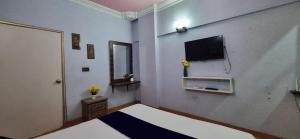 a bedroom with a bed and a tv on the wall at One bedroom luxury apartment 1st floor with kitchen in Karachi