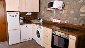 a kitchen with a white refrigerator and a dishwasher at Къща за гости ФЪН ШУЙ 88 in Dobrinishte