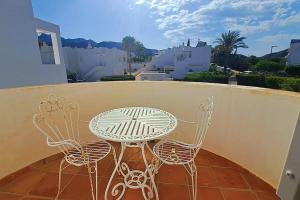 Una mesa y dos sillas en un balcón. en Casa Blanca - Mojacar Playa, en Mojácar