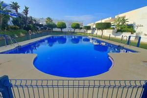 Una gran piscina con agua azul en un edificio. en Casa Blanca - Mojacar Playa, en Mojácar